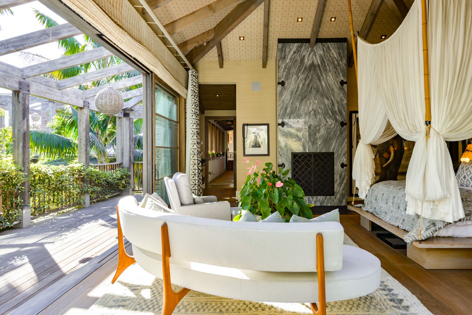 Balinese-inspired primary suite featuring a private covered terrace, soaring ceilings, natural wood accents, and seamless indoor-outdoor living at a private Malibu estate.