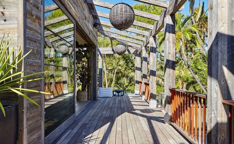 Covered wood deck with tropical landscaping inspired by Balinese design at a private Malibu estate.