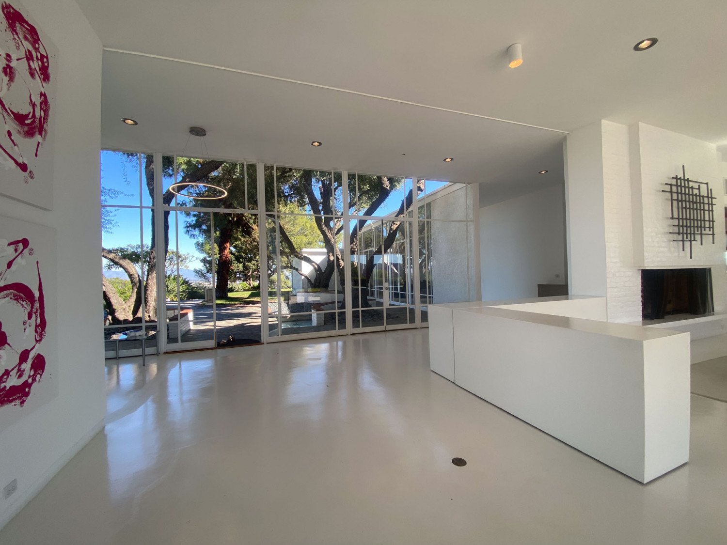 Light-filled mid-century interior with glass walls, fireplace and courtyard views