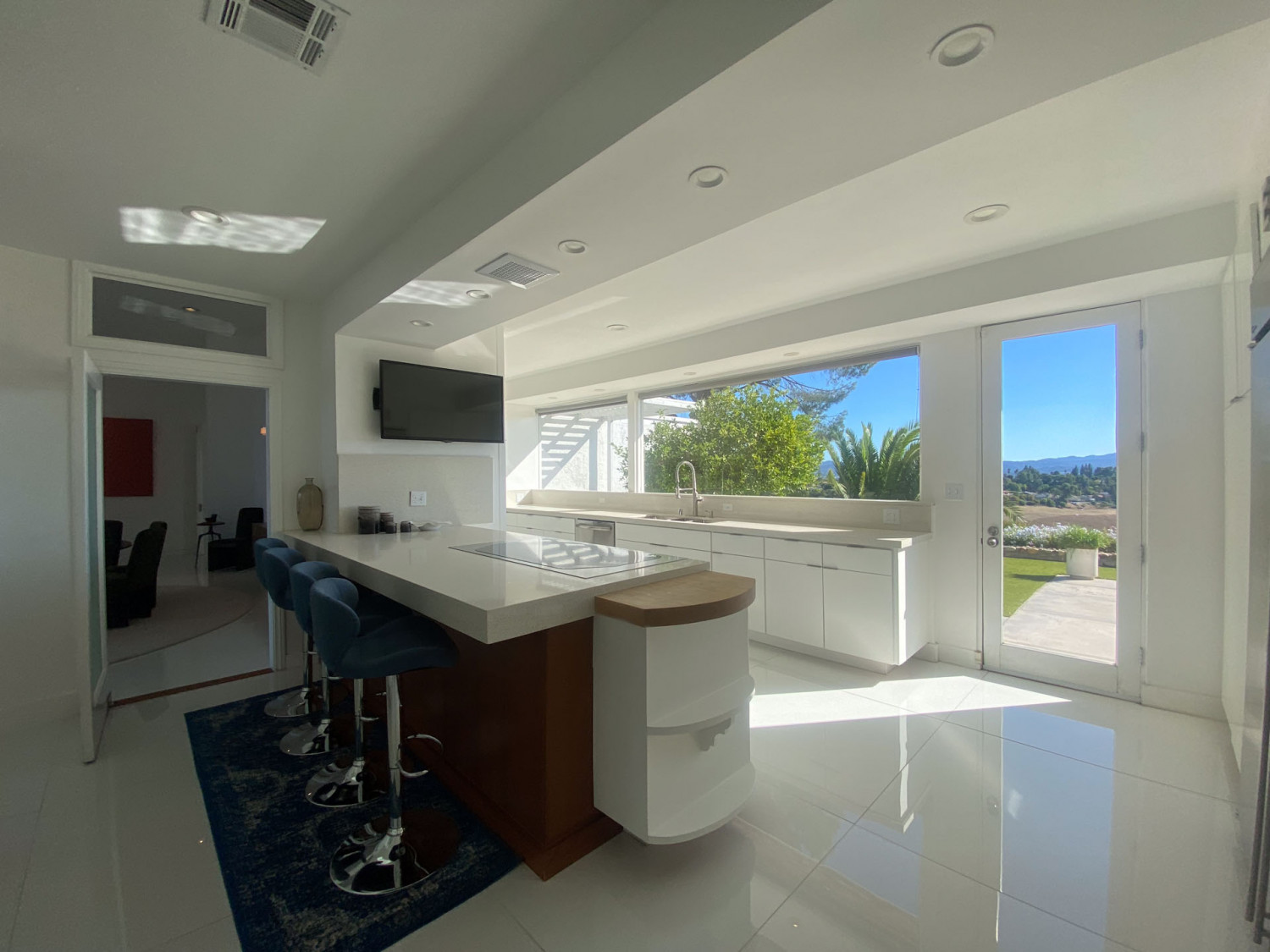 Bright kitchen with large island, white cabinetry and views of the surrounding hills