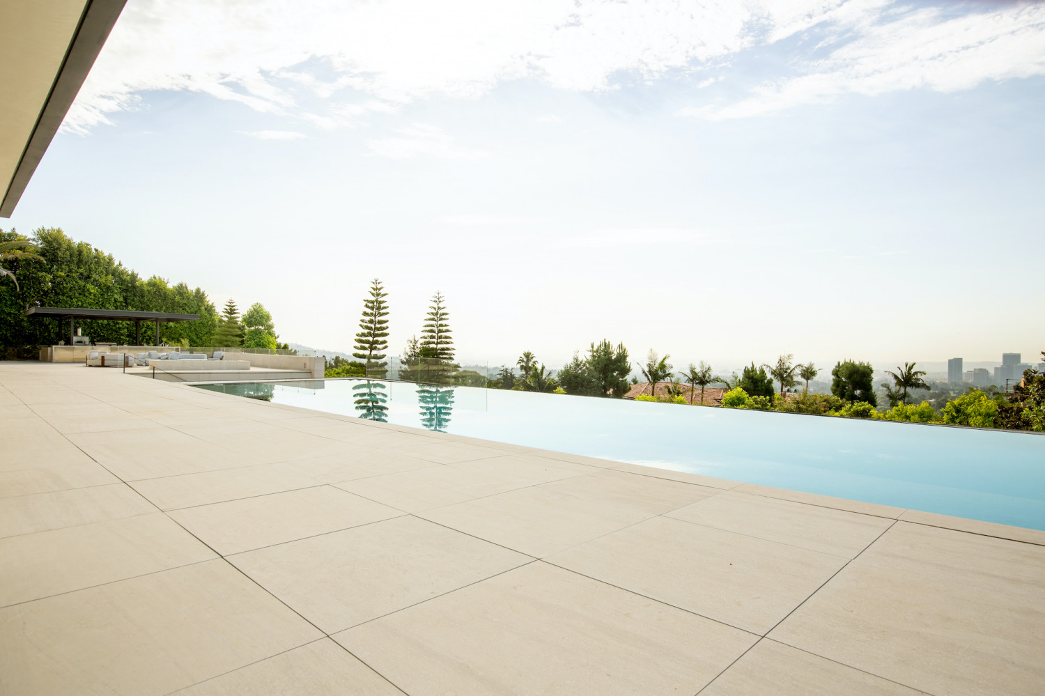 Infinity-edge pool with panoramic Los Angeles skyline views and expansive outdoor entertaining spaces.