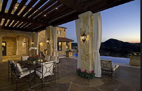 Elegant outdoor terrace overlooking vineyards and mountain views at sunset.