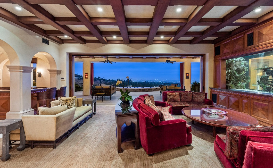 Elegant living room featuring soaring ceilings, abundant natural light, and panoramic city views.