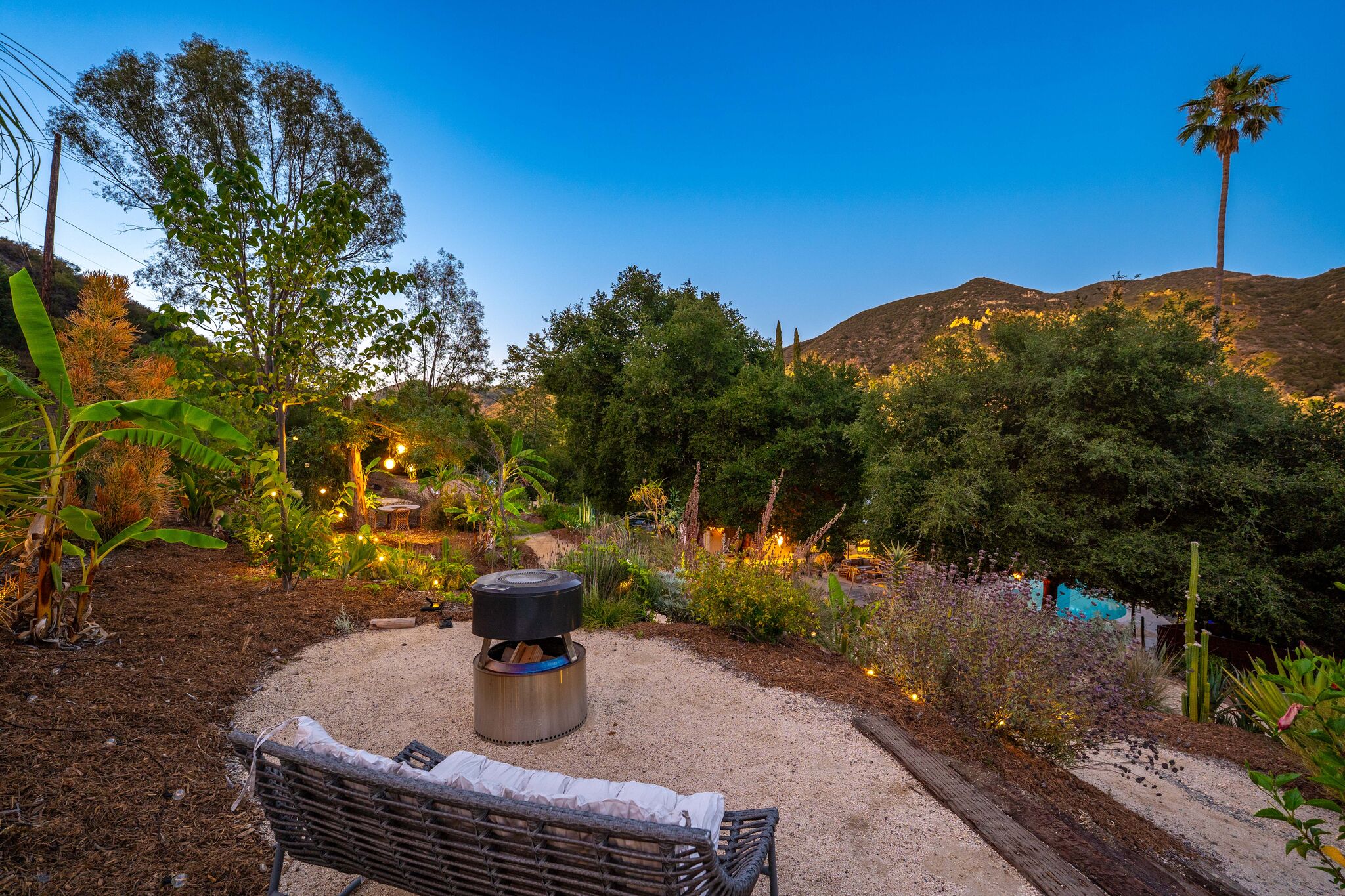 Private retreat gardens at sunset with warm landscape lighting and tranquil outdoor spaces.