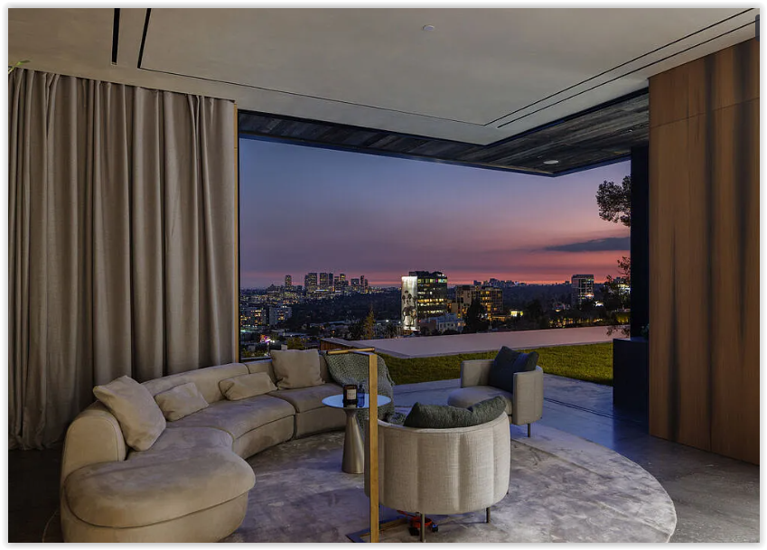Sophisticated indoor-outdoor lounge opening to panoramic Los Angeles skyline views at twilight.