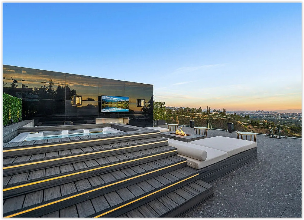 Luxury Bel Air estate featuring a private spa terrace with built-in hot tub, fire feature, lounge seating, and panoramic Los Angeles skyline views.