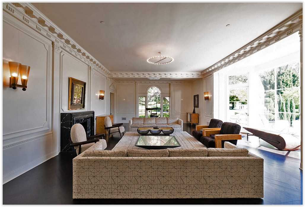 Sophisticated formal living room with classic moldings, fireplace, and garden views inside a Beverly Hills estate.