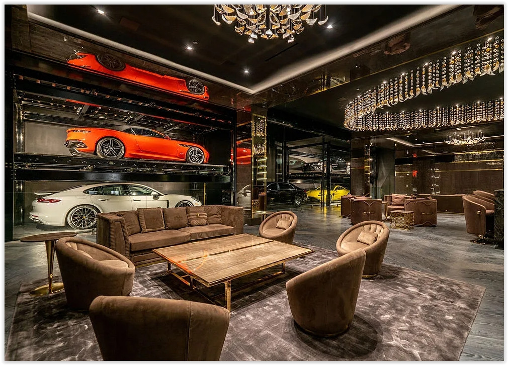 Designer entertainment lounge with custom bar, dramatic chandeliers, luxury finishes, and collector car display.