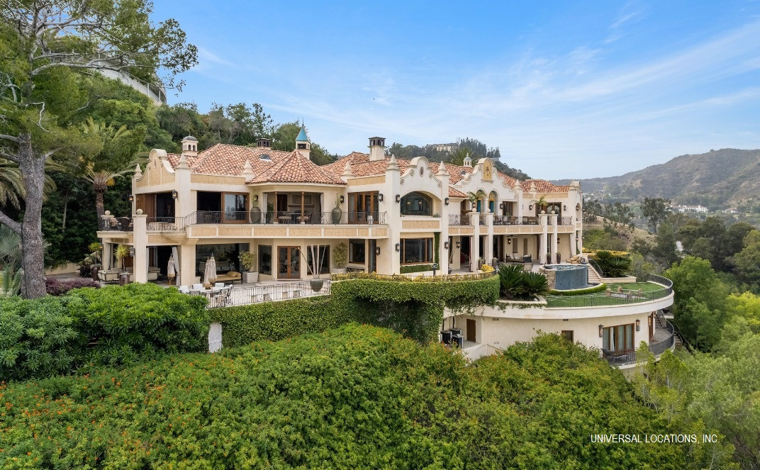 Mediterranean hillside estate overlooking Los Angeles with expansive terraces, lush landscaping, and panoramic views.