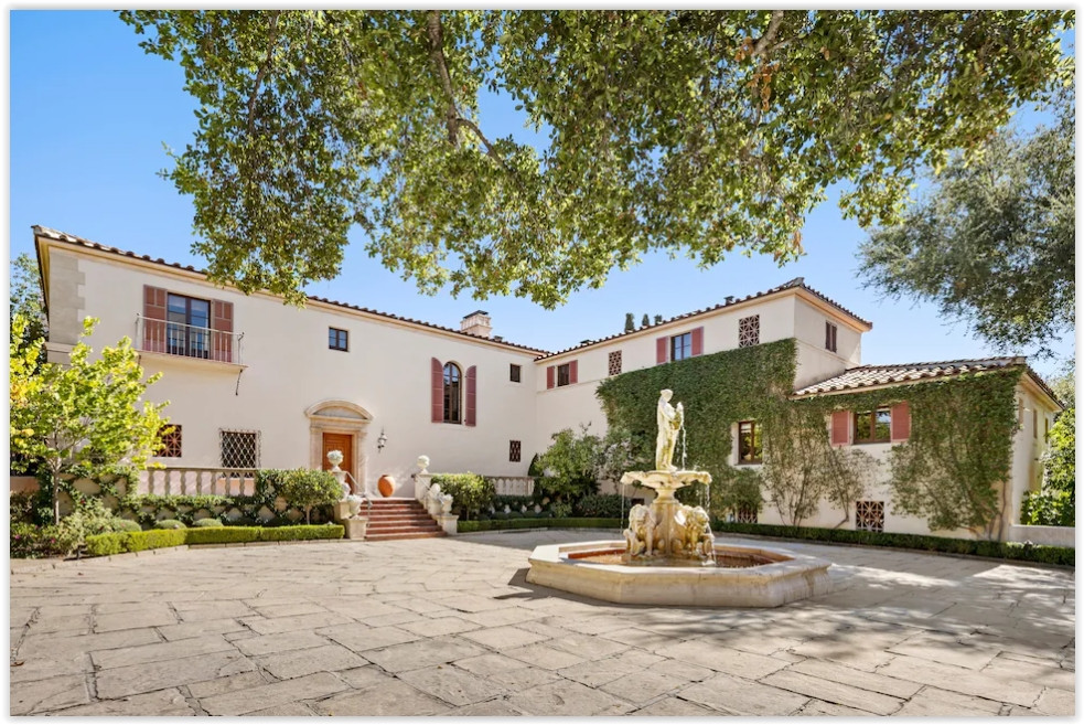 Elegant Spanish Colonial estate featuring a formal courtyard with a decorative fountain and Mediterranean architecture.