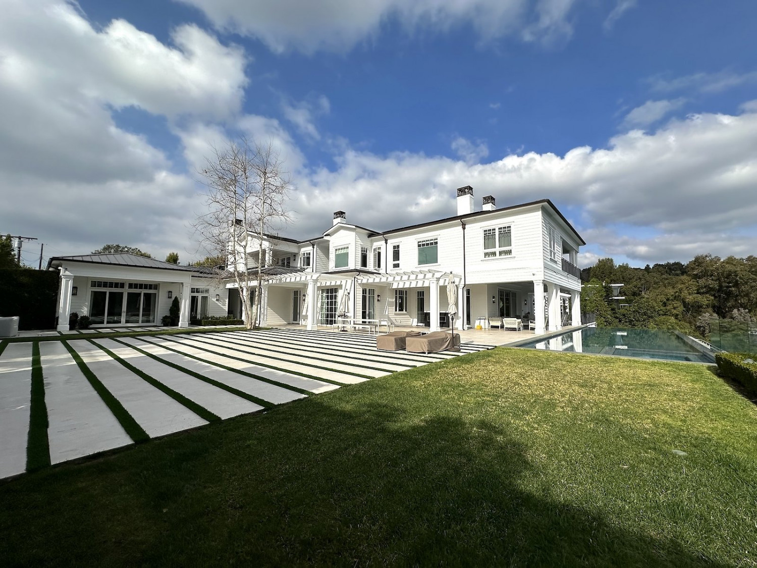 Modern Private Estate Home Events showcasing a resort-style infinity pool, expansive lawn, and elegant outdoor entertaining spaces.
