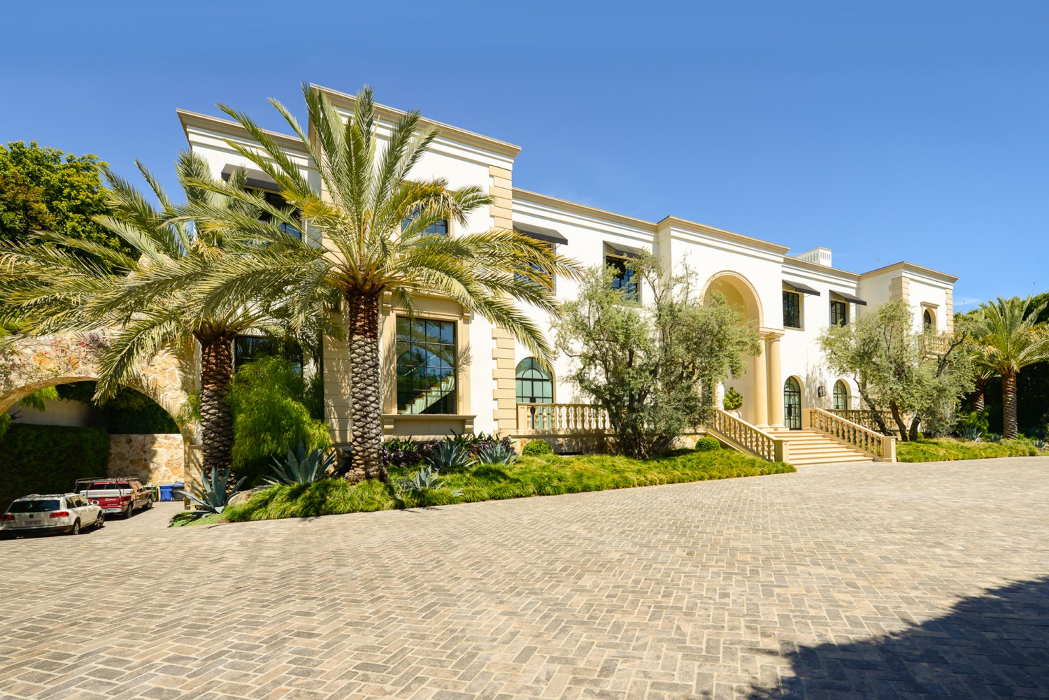 Grand Bel Air estate exterior with palm trees, formal entry steps and expansive motor court