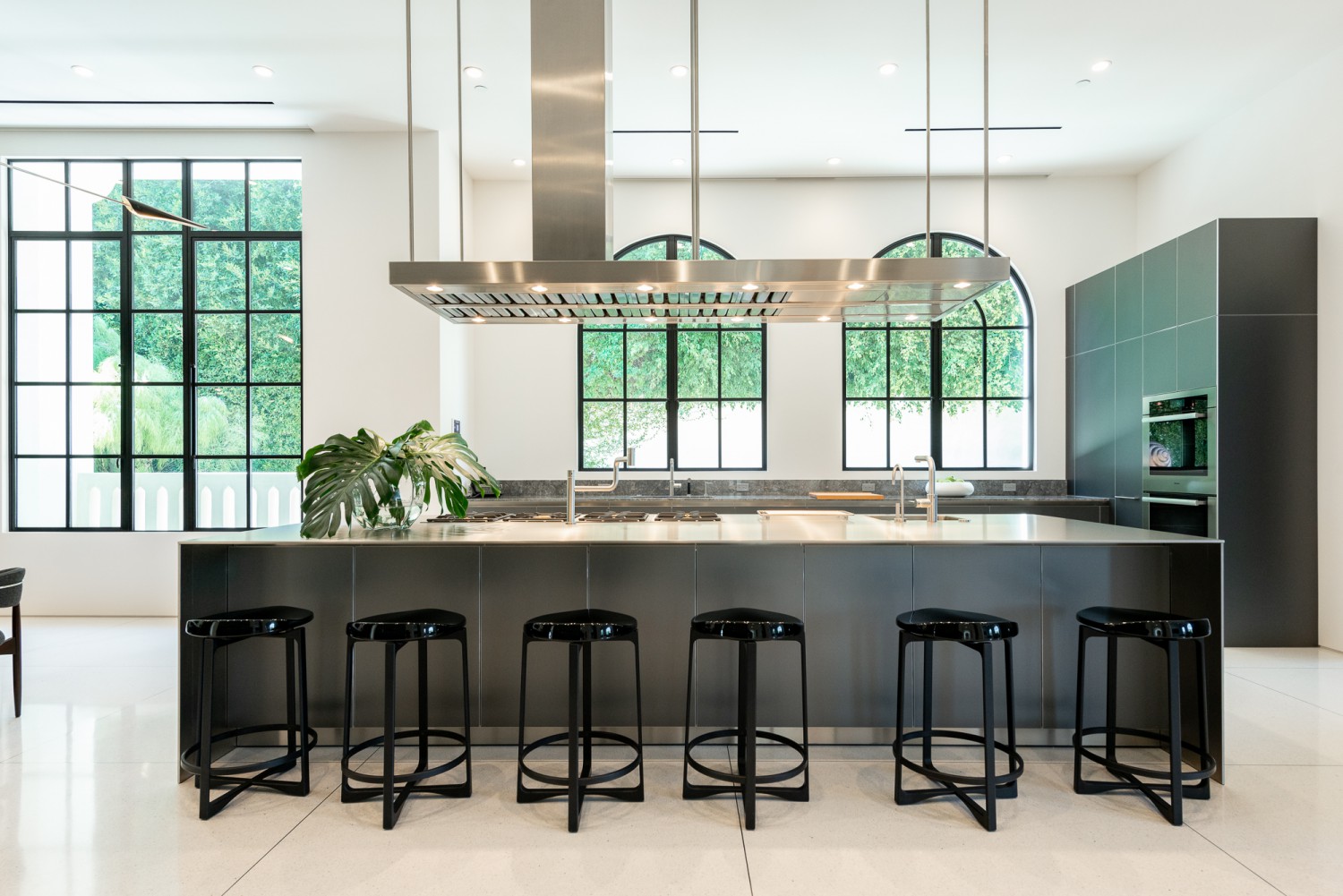 Private bar with marble counters, brass stools and built-in shelving for entertaining