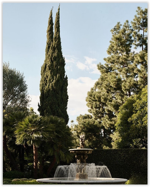 Formal fountain surrounded by mature trees and gardens at C199-BA Bel Air estate
