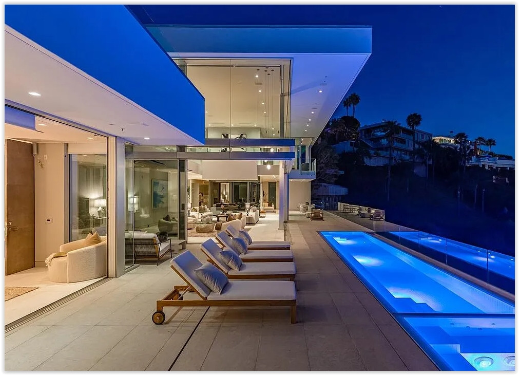 Modern Los Angeles estate with illuminated infinity pool, open living spaces and city views at night