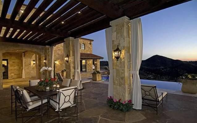 Covered outdoor terrace with stone details and panoramic Malibu mountain views