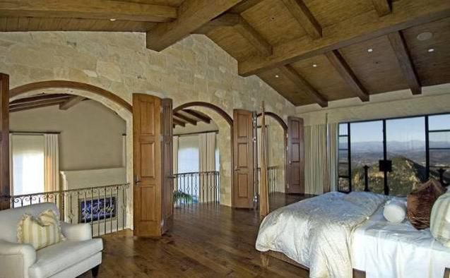 pacious bedroom with exposed wood beams and panoramic Malibu views