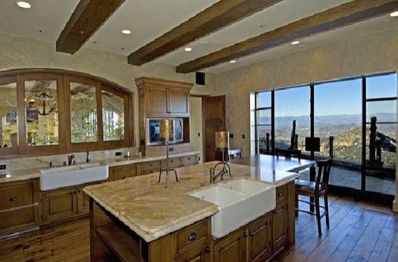 Spacious Malibu estate kitchen with wood cabinetry, beams, and canyon views