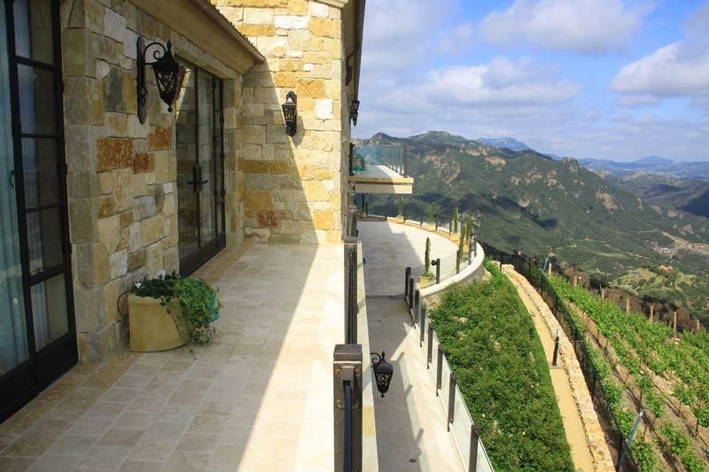 Stone balcony overlooking hillside landscaping and panoramic Malibu mountain views