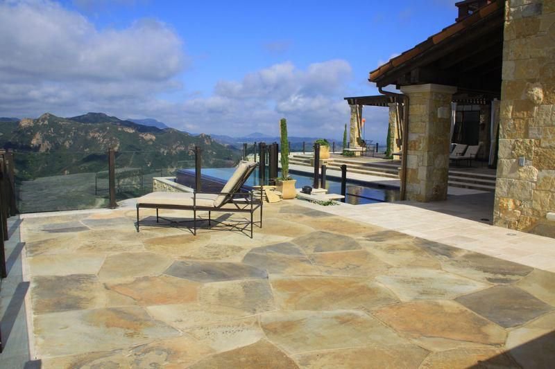 Stone pool terrace at a Malibu private estate with sweeping mountain and canyon views