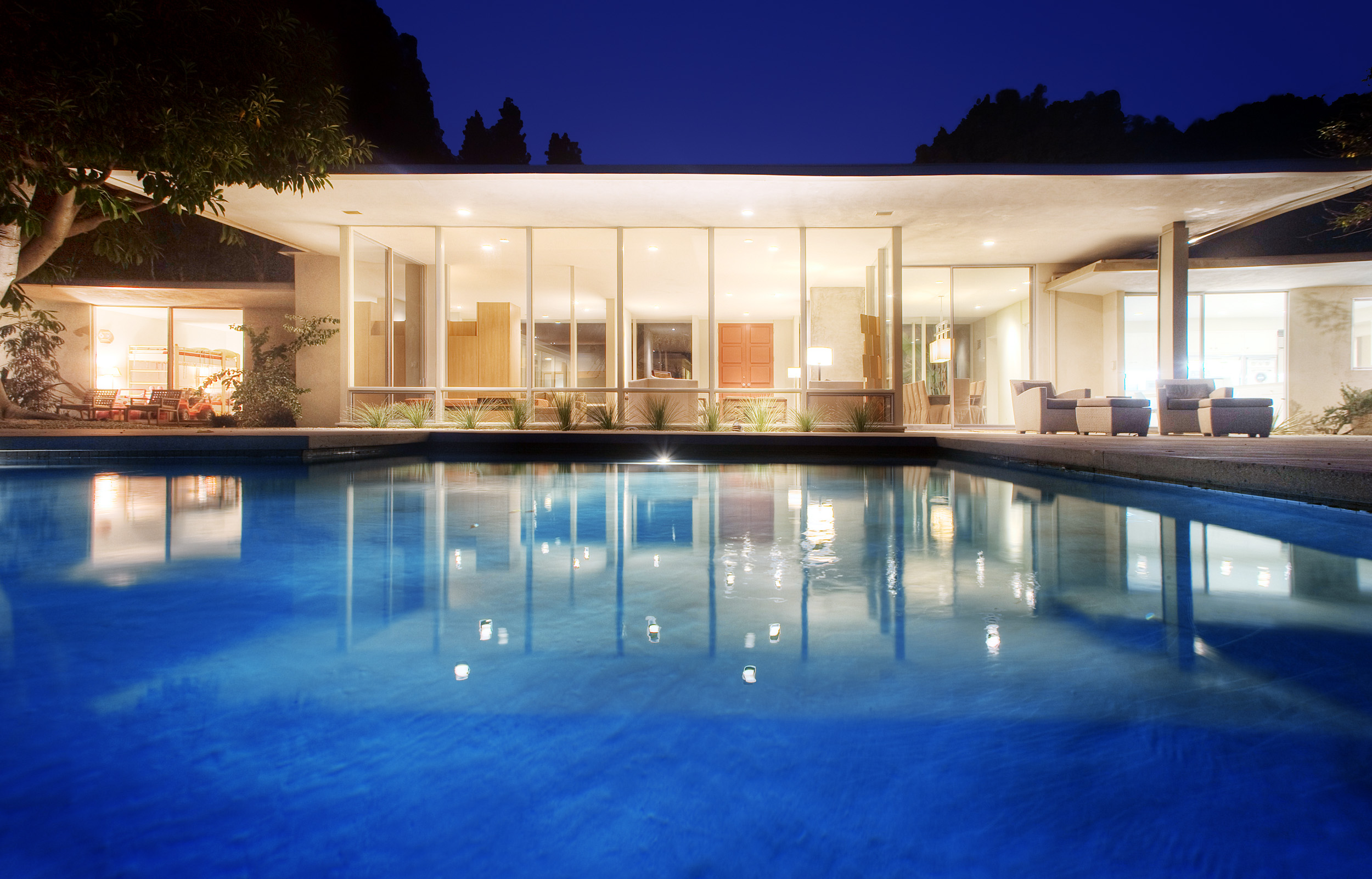 Beverly Hills private estate illuminated at night beside the pool
