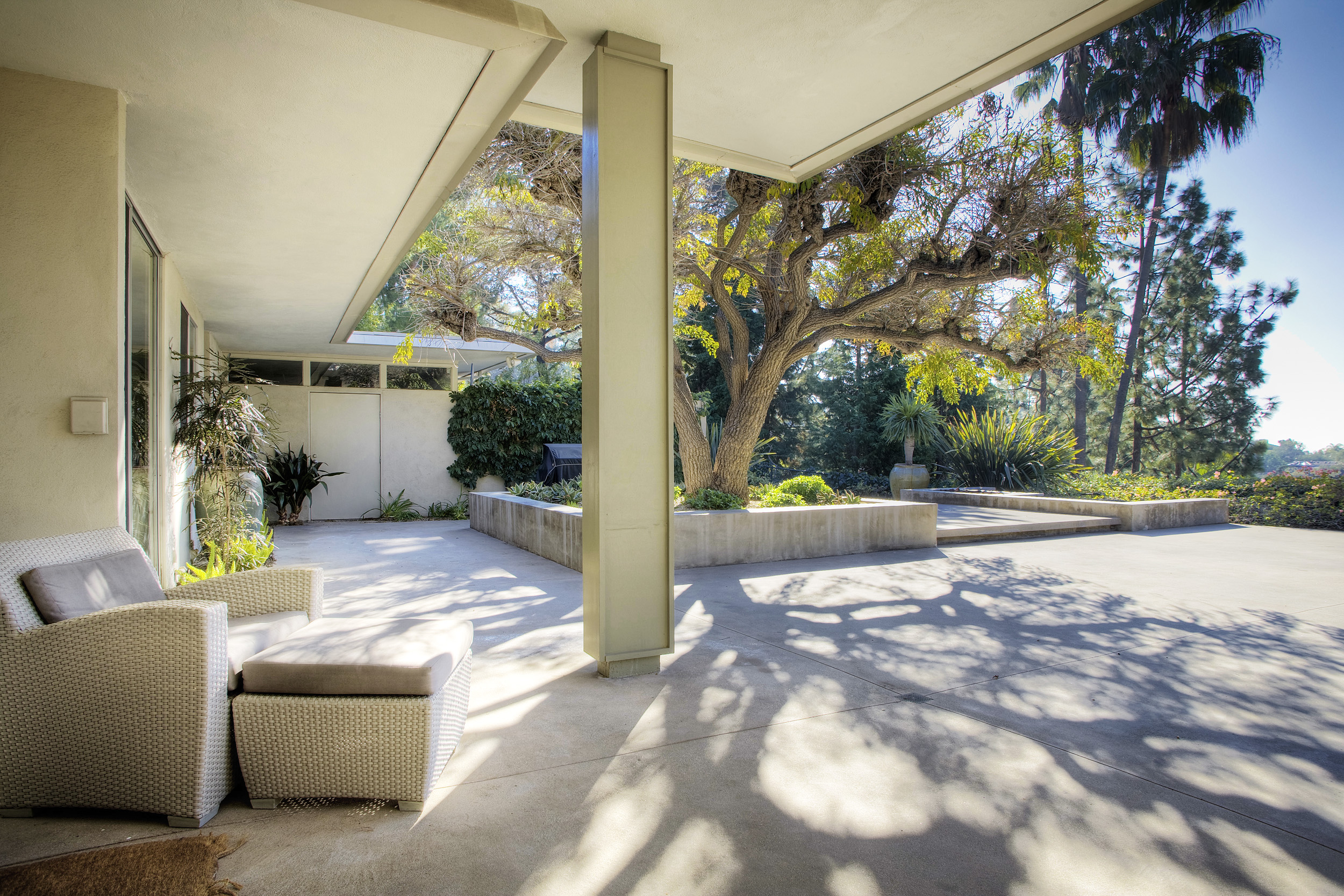 Covered patio at Beverly Hills private estate with landscaped garden views