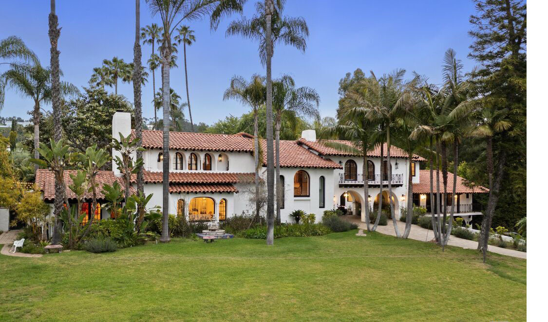 Wide exterior view of Spanish-style Beverly Hills private estate with expansive front lawn