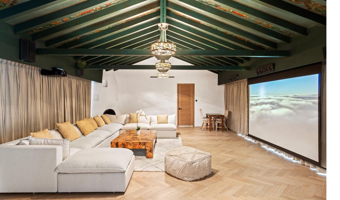 Media room with large sectional seating and screening wall in Beverly Hills estate