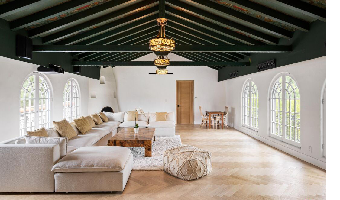 Large lounge with arched windows, wood-beam ceiling, and spacious seating area